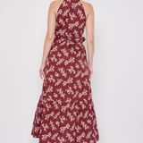 Model wearing a printed sleeveless midi dress featuring a flowing silhouette and vibrant allover pattern.