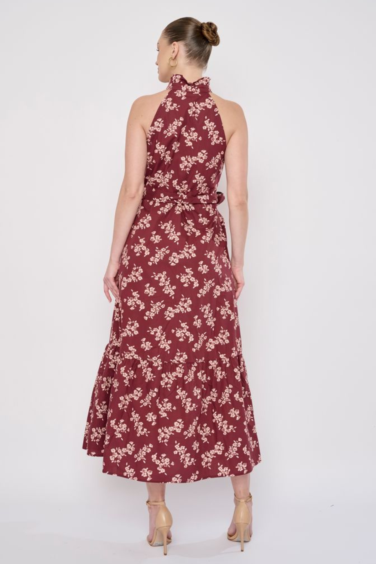 Model wearing a printed sleeveless midi dress featuring a flowing silhouette and vibrant allover pattern.