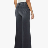 Person wearing dark flared jeans on a white background