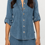 Women's blue denim button-front shirt featuring a collared neckline and long sleeves.