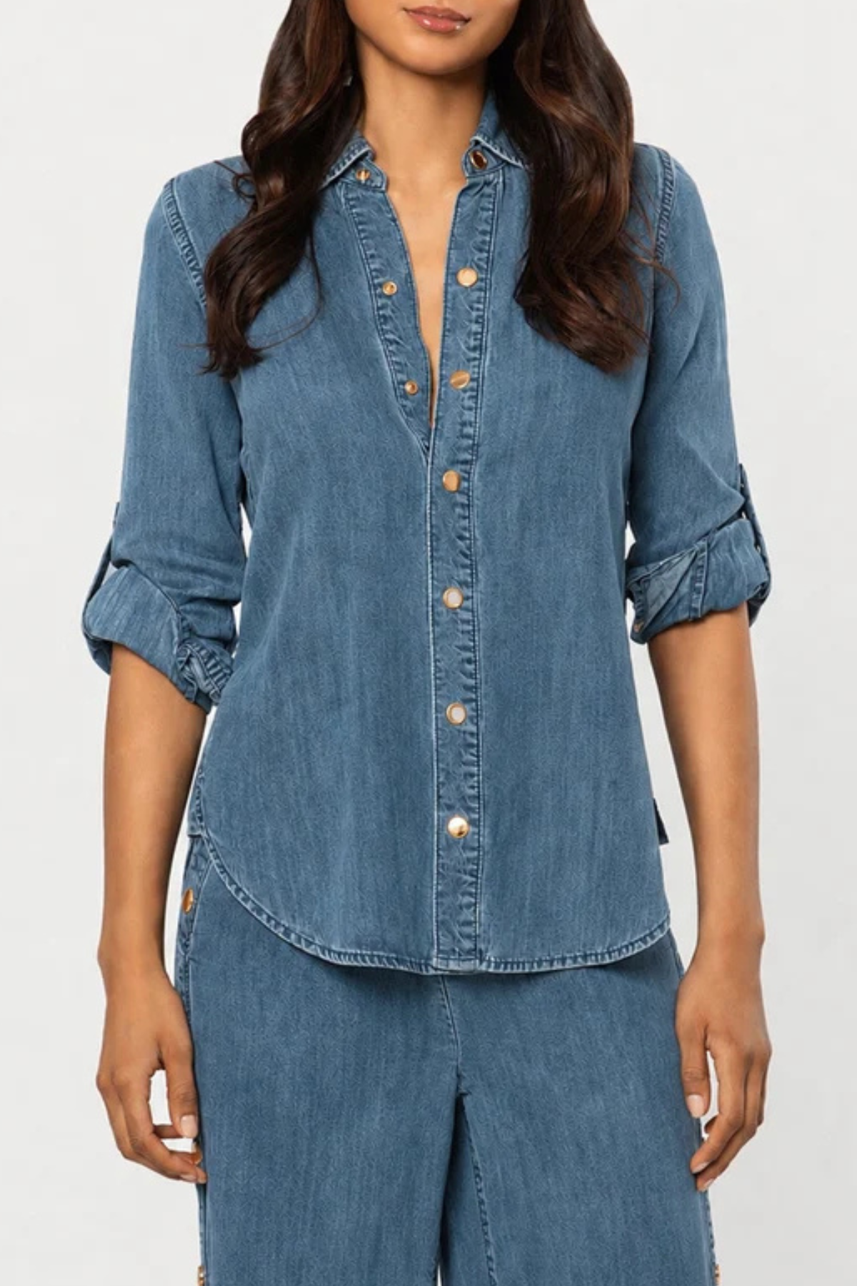 Women's blue denim button-front shirt featuring a collared neckline and long sleeves.