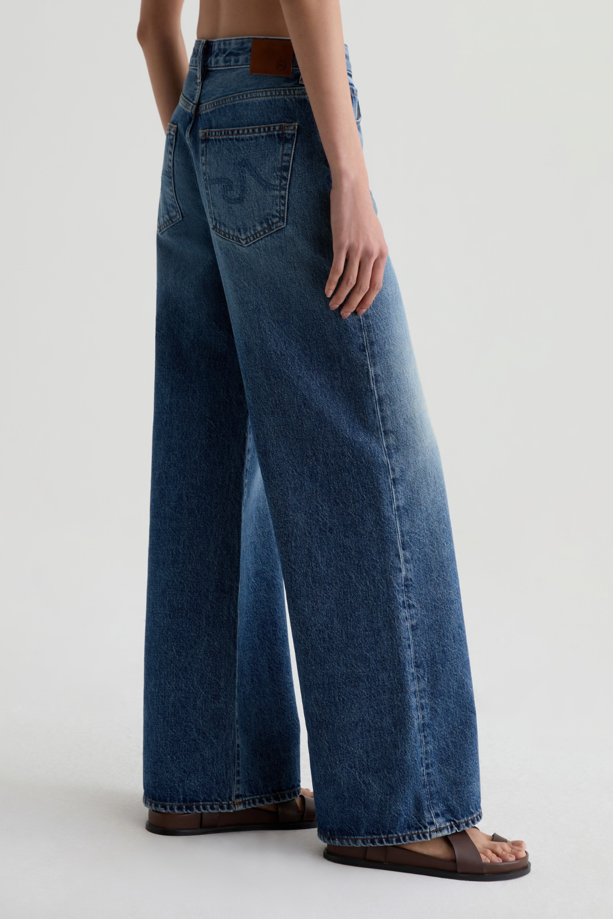 Model wearing high-rise wide-leg denim pants with a relaxed, full-length silhouette.