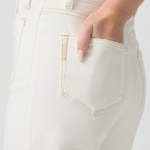 Close-up of a person wearing light-colored pants with a neutral background