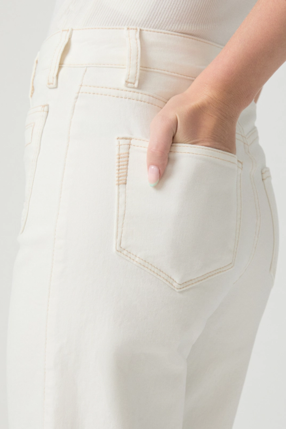 Close-up of a person wearing light-colored pants with a neutral background