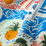 Colorful fabric with pineapple and beach-themed patterns