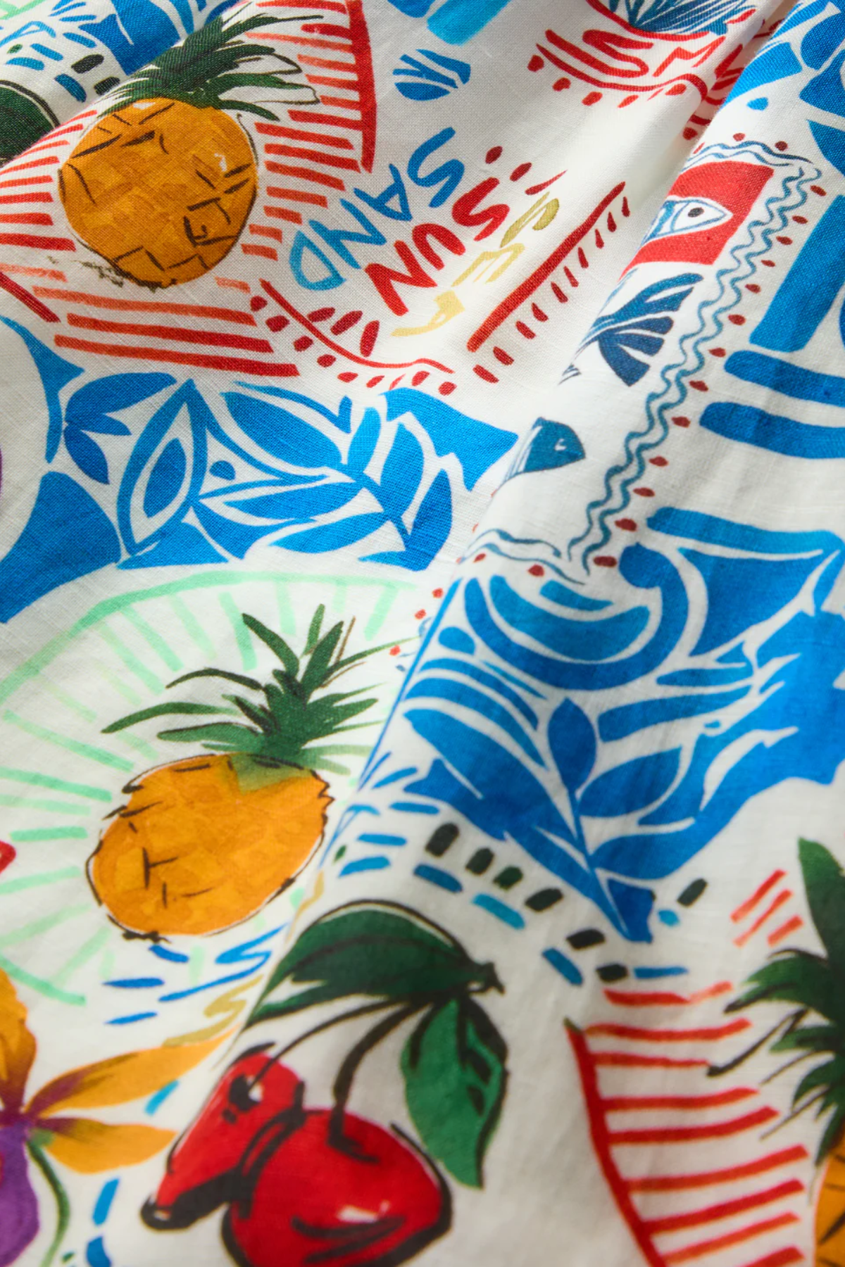 Colorful fabric with pineapple and beach-themed patterns