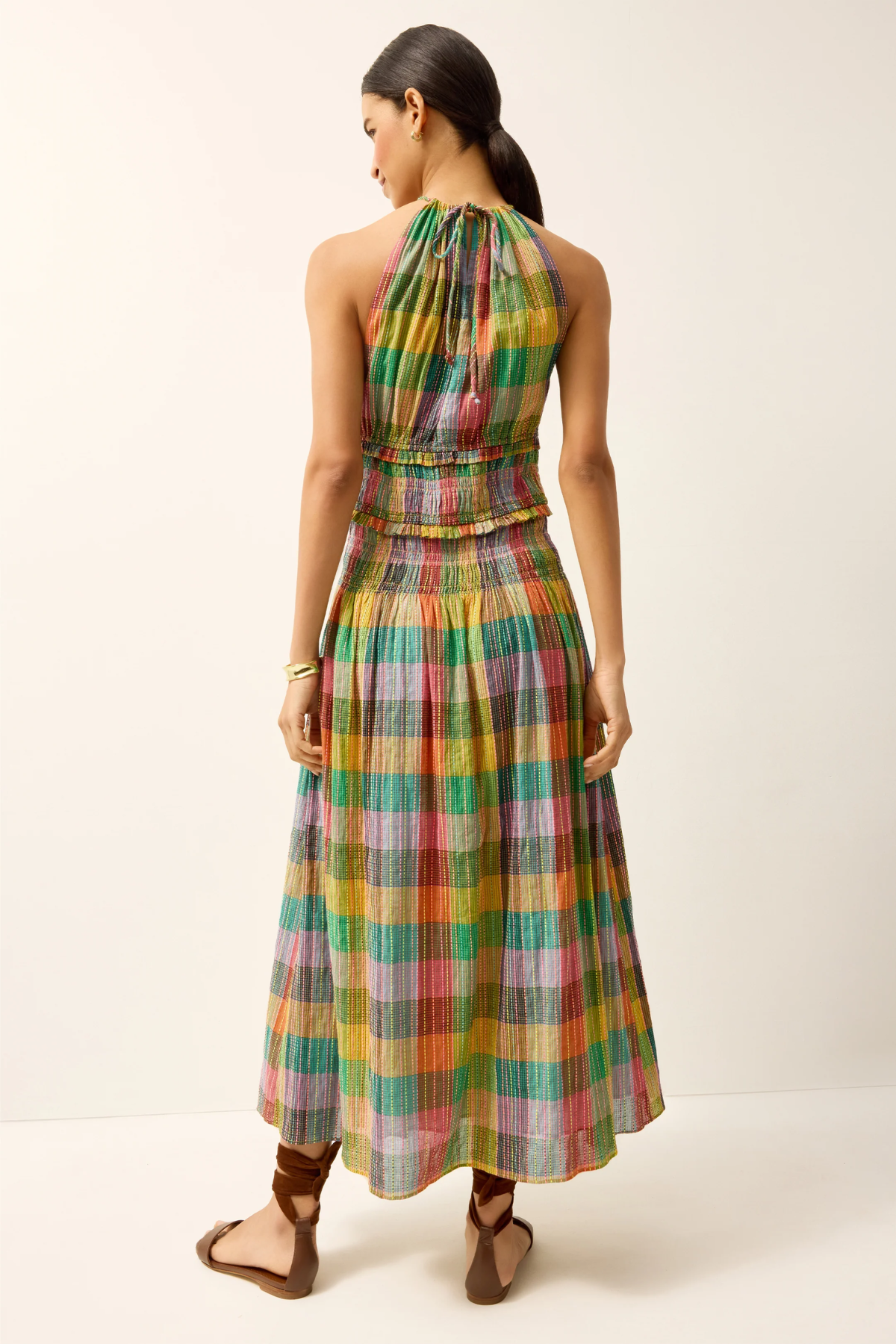 Woman wearing a colorful plaid dress on a white background