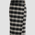 A black and off-white plaid wrap pencil skirt with a small gold button detail on the front, shown against a solid light gray background.