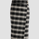 A black and off-white plaid wrap pencil skirt with a small gold button detail on the front, shown against a solid light gray background.