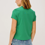 Person wearing a green t-shirt and blue jeans on a plain background