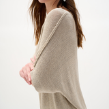 Woman wearing a beige sweater on a white background