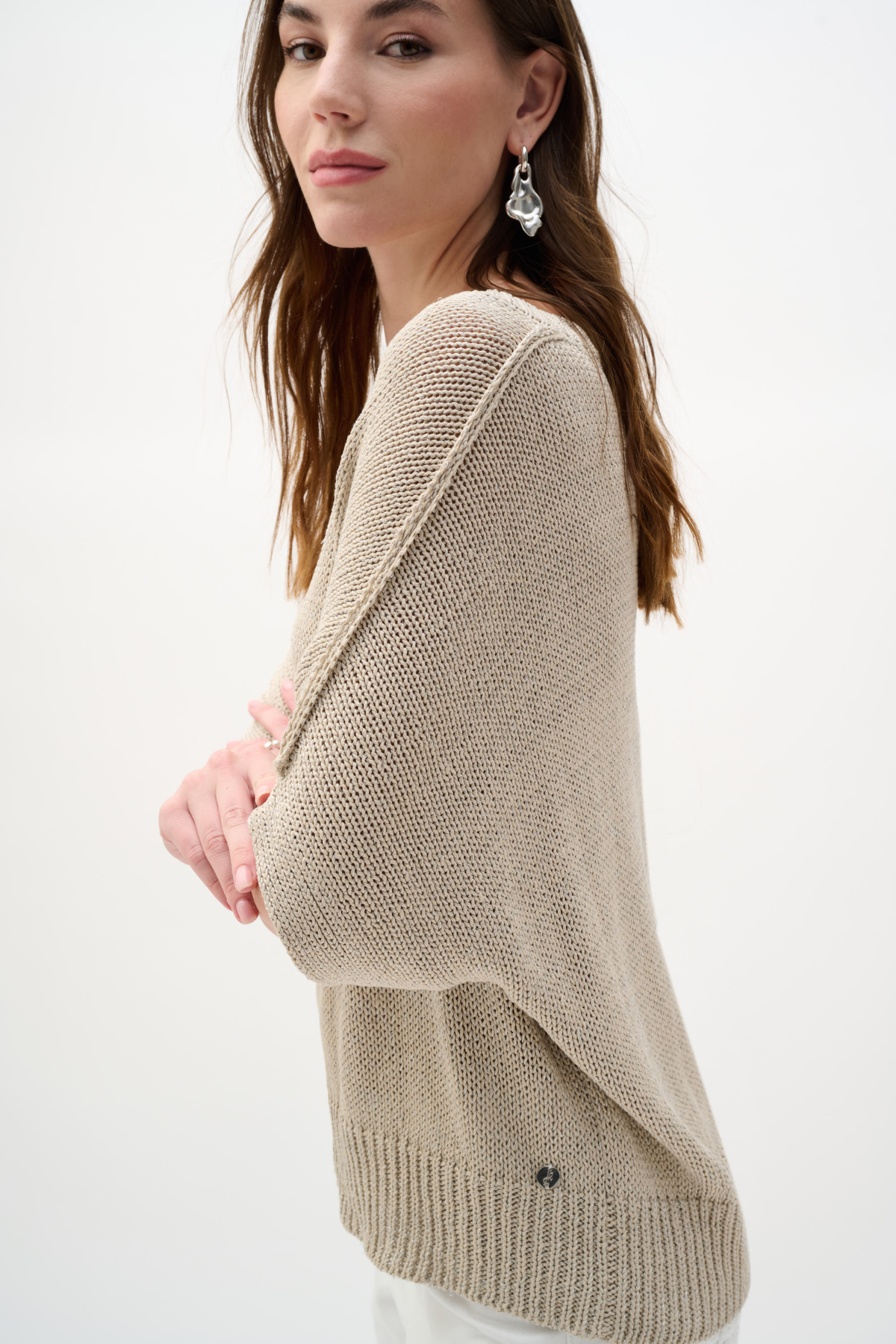 Woman wearing a beige sweater on a white background