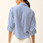 Woman wearing a blue and white striped shirt with a beige background