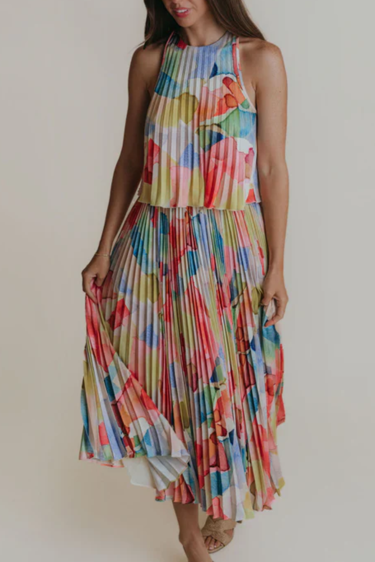 Woman wearing a colorful patterned dress against a plain background