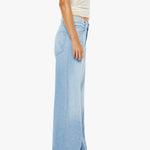 Person wearing light blue wide-leg jeans on a white background