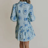 Woman wearing a blue floral dress against a plain background