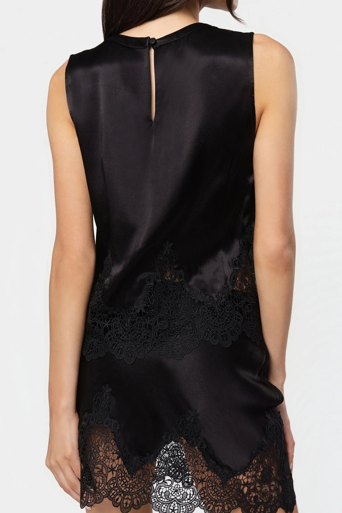 Black sleeveless top with lace detailing on a white background