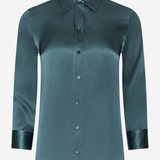A long-sleeve satin button-up shirt in a muted teal-green color, featuring a pointed collar, dark buttons, and contrasting dark green satin cuffs, shown against a plain light gray background.