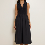 Woman wearing a black sleeveless dress against a plain background