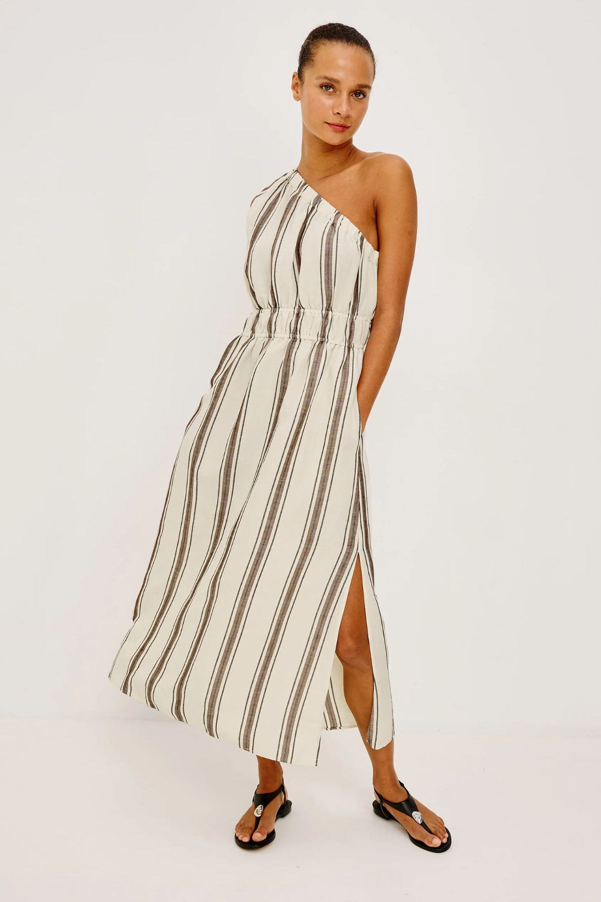 Woman wearing a striped one-shoulder dress on a white background