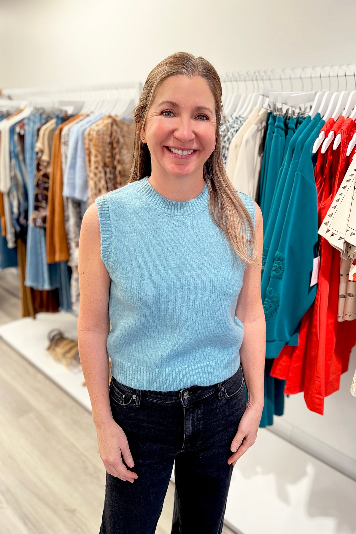 Sleeveless crew neck knit top in a neutral tone, styled simply