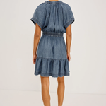 Woman wearing a denim dress on a white background