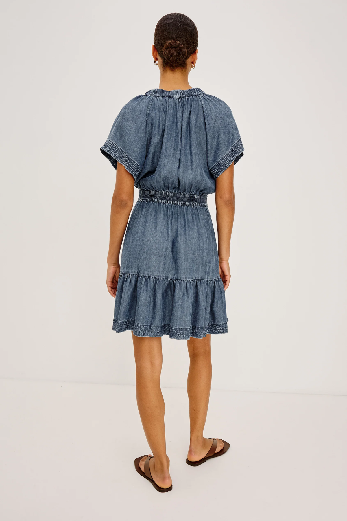 Woman wearing a denim dress on a white background