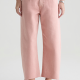 Person wearing pink pants and brown shoes on a white background