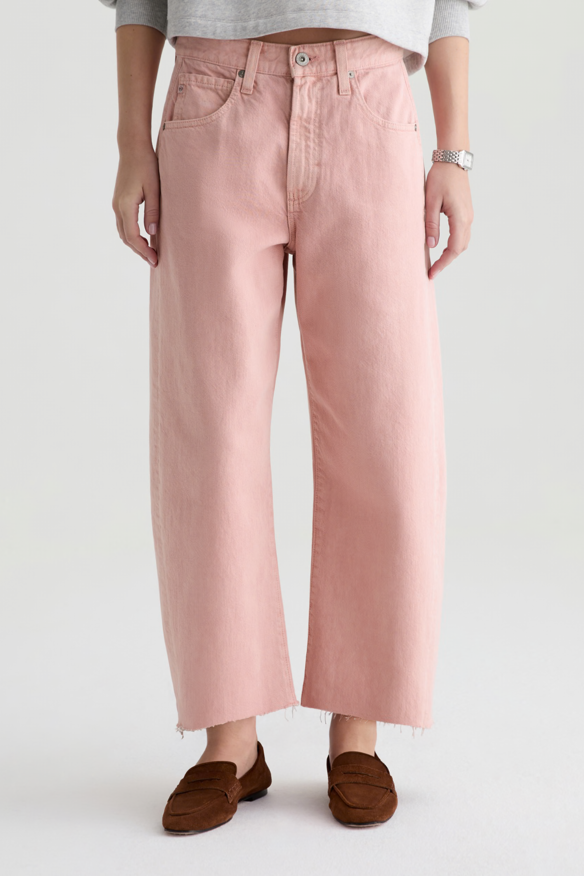 Person wearing pink pants and brown shoes on a white background