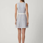 back of woman in multicolored dress on white background 