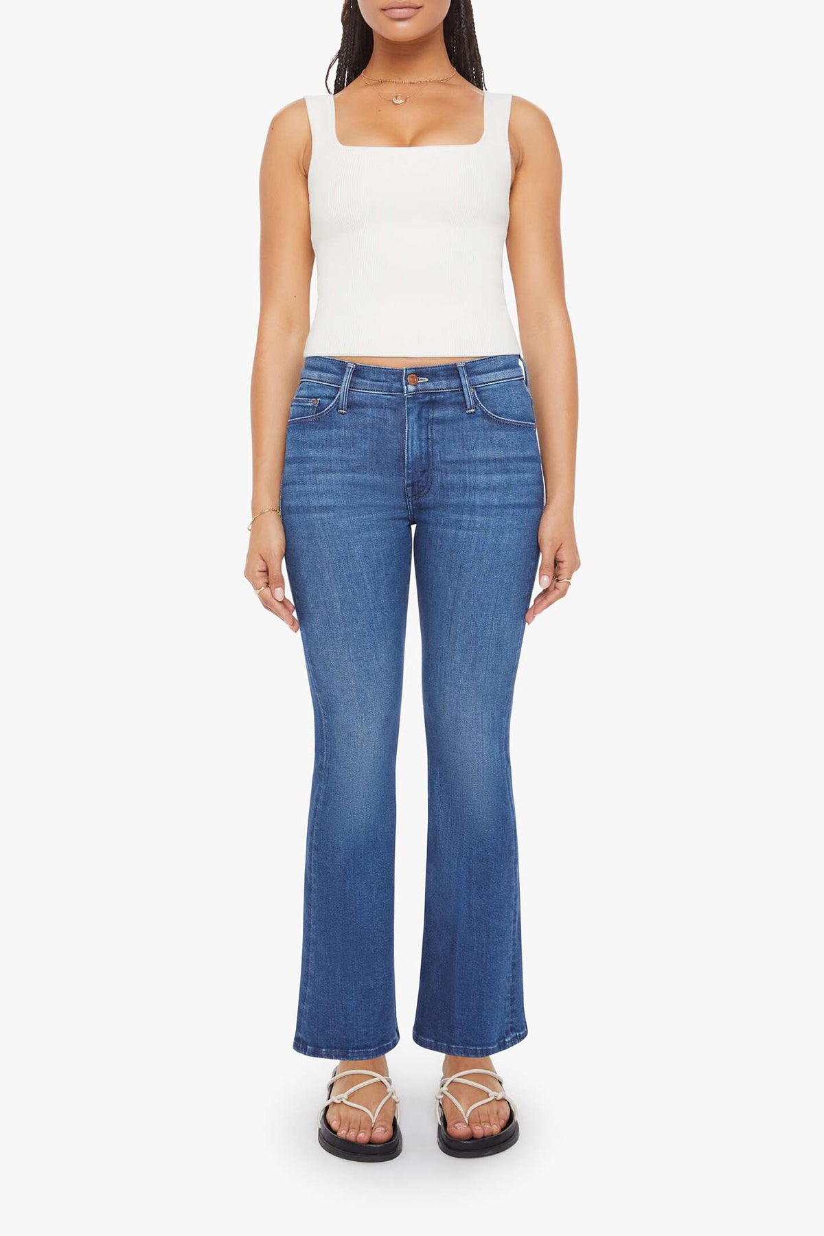 Woman wearing mid-wash flared jeans with a slim fit through the hip and gentle flare at the hem.