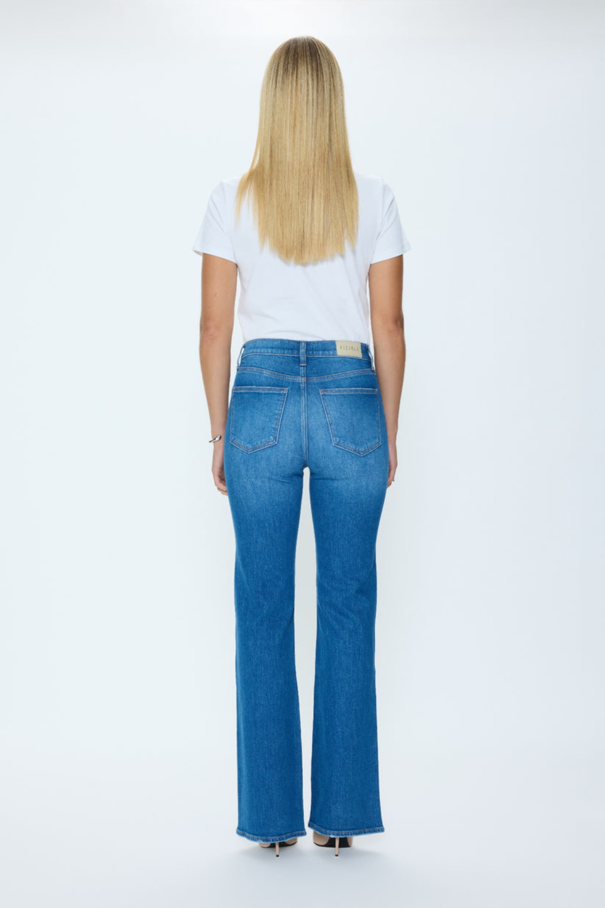 Person wearing blue jeans and a white t-shirt on a white background