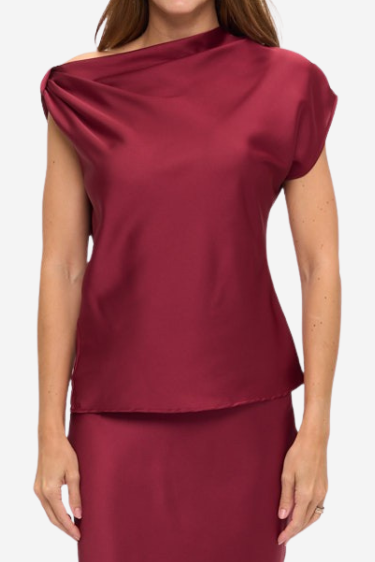 A woman wearing a draped off-the-shoulder satin top and matching skirt in a deep burgundy red, shown against a plain light gray studio background.