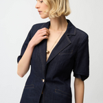 Woman wearing a navy blazer on a white background