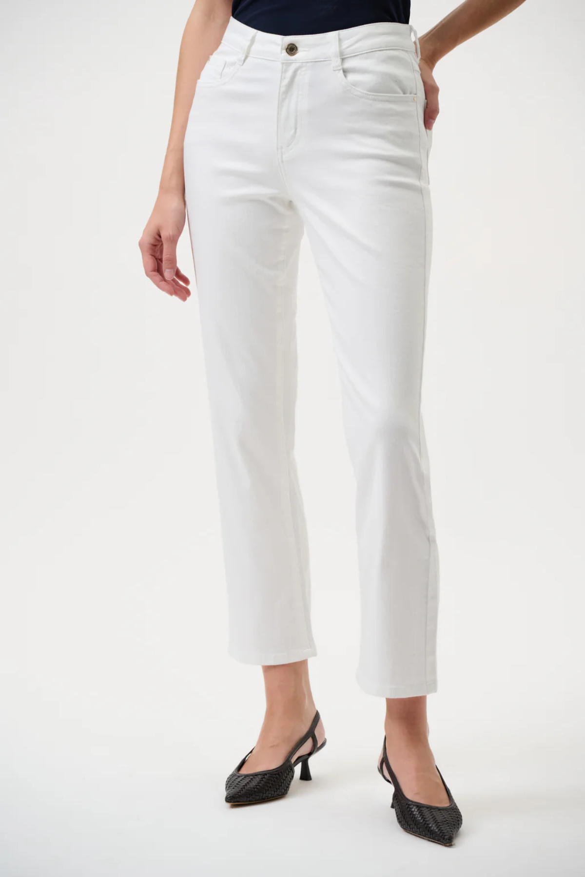 Person wearing white pants on a plain background