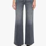 A model from the waist down wearing high-waisted, wide-leg gray denim jeans with a faded wash, paired with black pointed-toe heels against a plain white background.