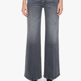 A model from the waist down wearing high-waisted, wide-leg gray denim jeans with a faded wash, paired with black pointed-toe heels against a plain white background.