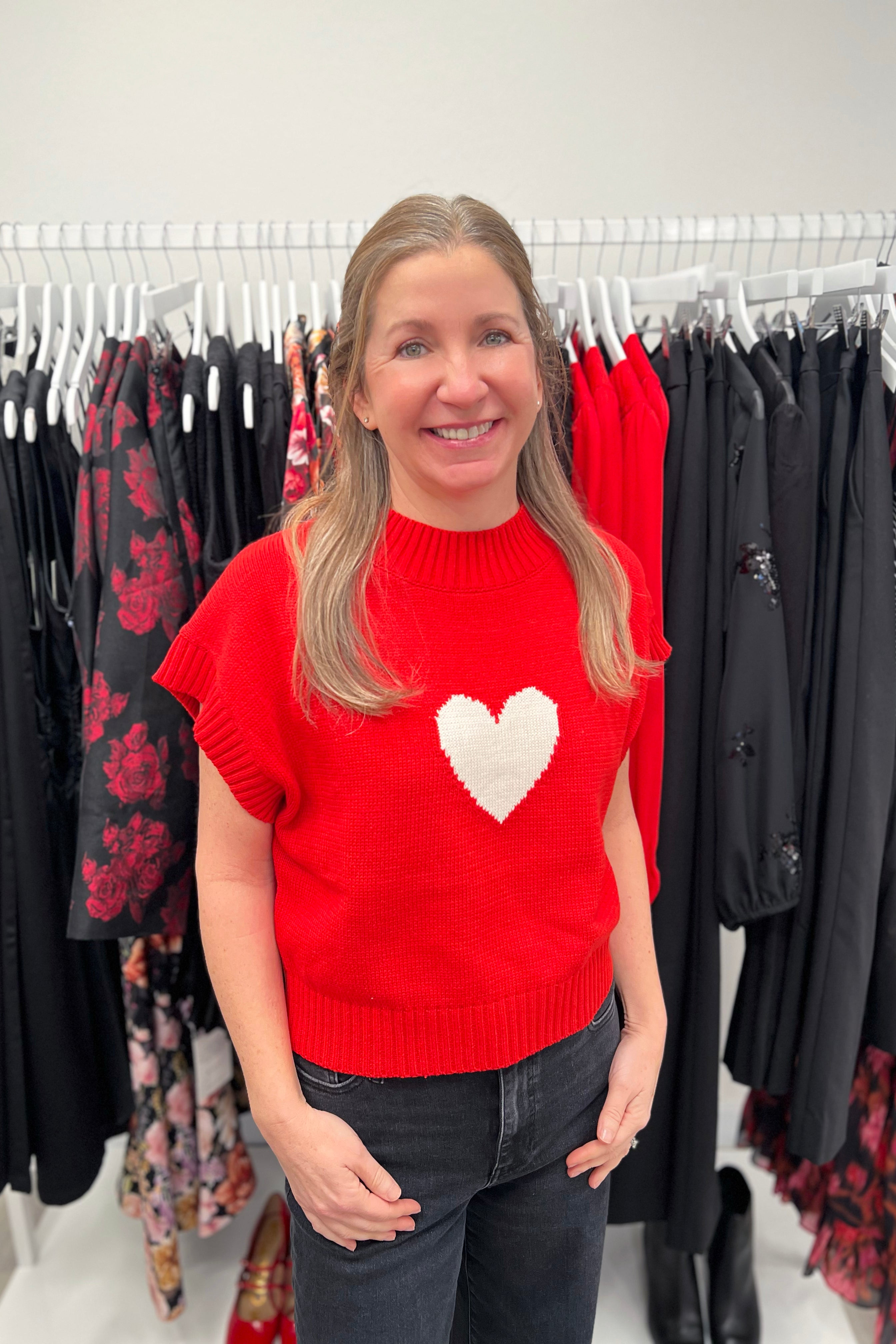 Knit sweater featuring a heart motif, styled casually with denim