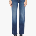 A model from the waist down wearing medium wash blue denim jeans with a straight-leg fit, paired with black pointed-toe ankle boots against a plain white studio background.