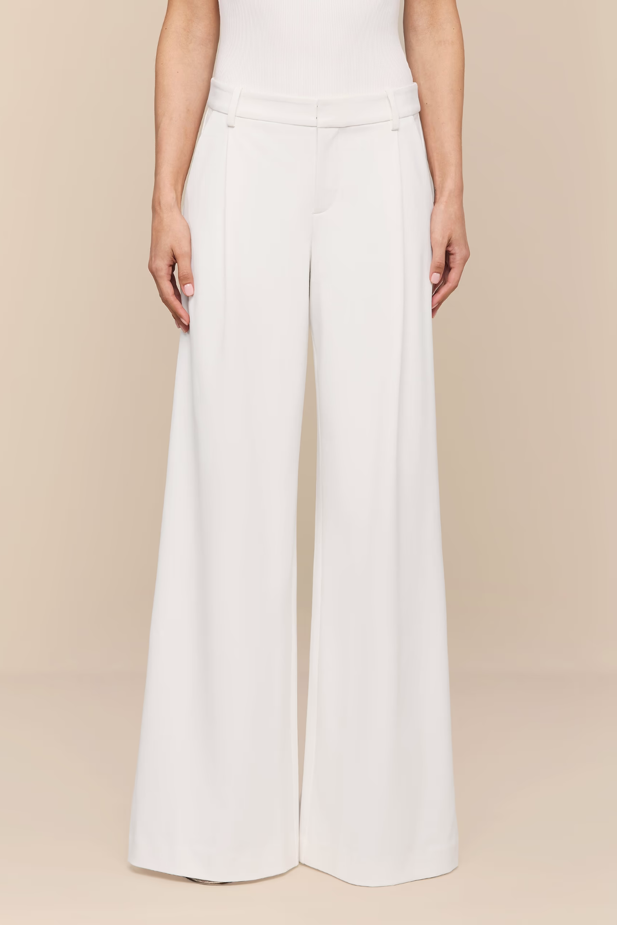 White wide-leg pants worn by a person on a beige background