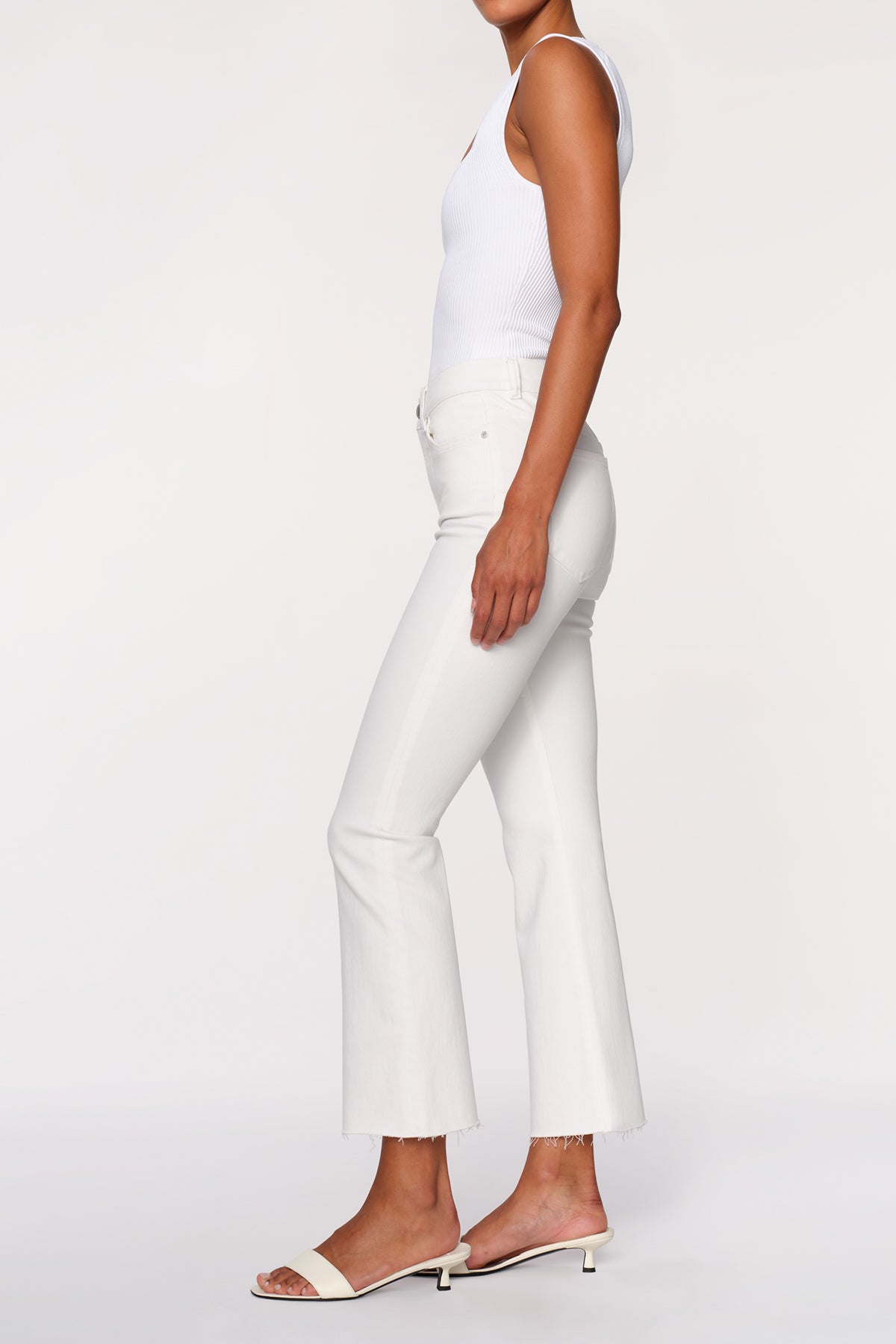 side view of woman in white denim on white background 