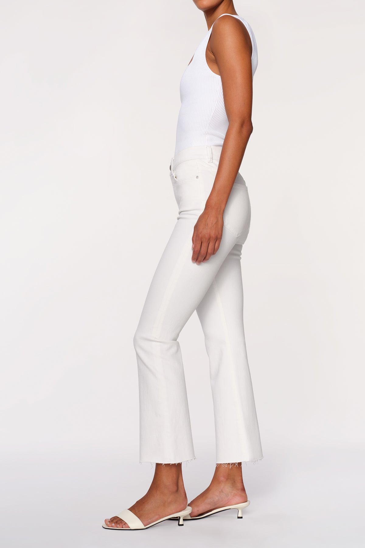 side view of woman in white denim on white background 