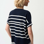 Woman wearing a black and white striped shirt against a plain background