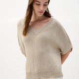 Woman wearing a beige knit top on a white background