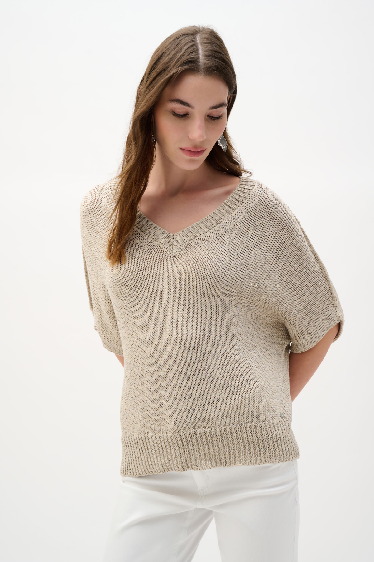 Woman wearing a beige knit top on a white background