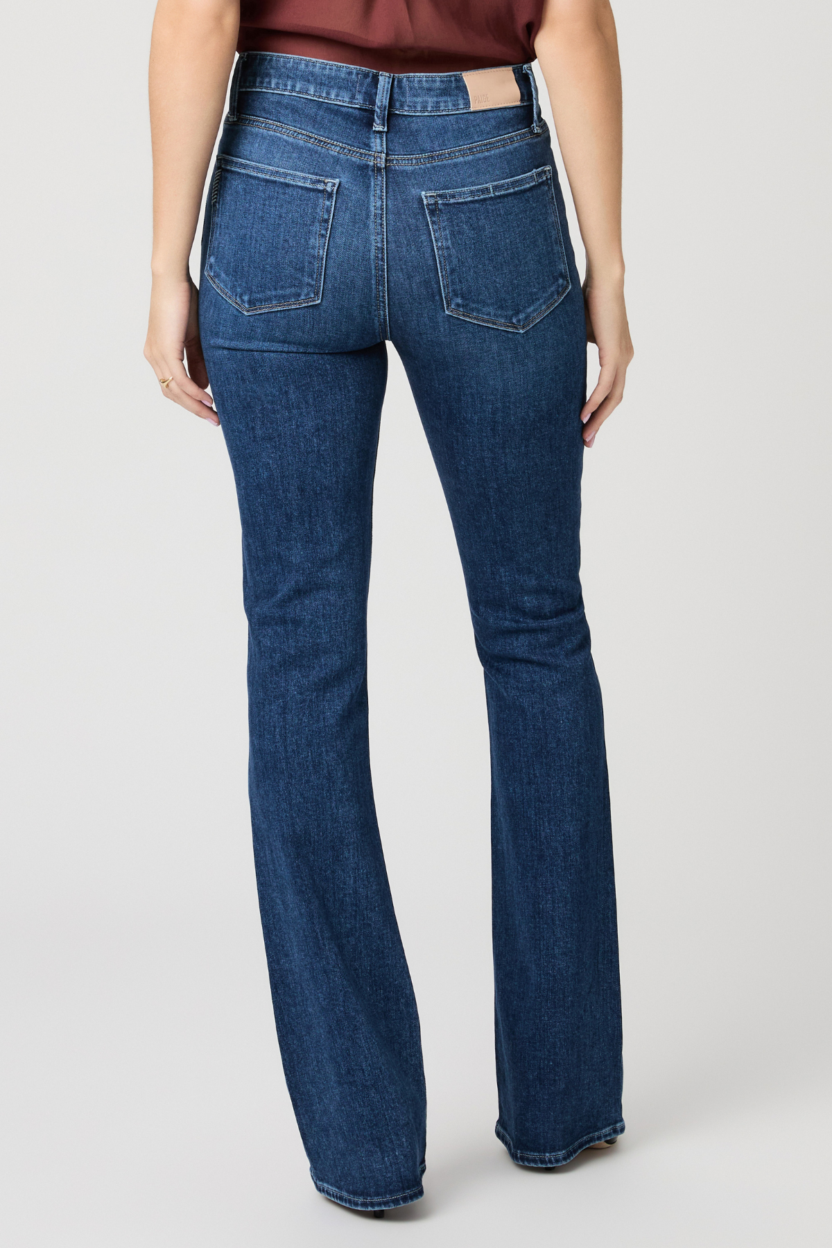 Blue jeans worn by a person on a white background