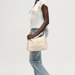 Woman holding a beige bag against a white background