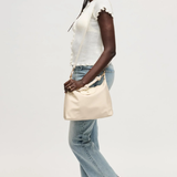 Woman holding a beige bag against a white background