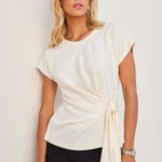 woman in white side knot detail blouse outside 