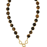 A beaded necklace featuring round brown and black tiger's eye beads with gold spacer rings, connected by a gold chain with a gold-tone pendant.